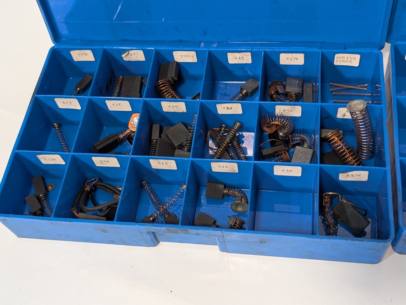 Large lot of assorted motor brushes as shown, two blue organizers included